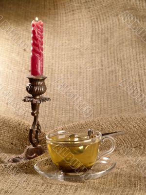 cup of green tea on hessian with honey spoon