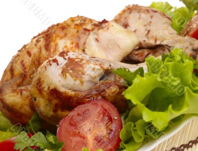 grilled chicken whole with vegetables on salad leafs