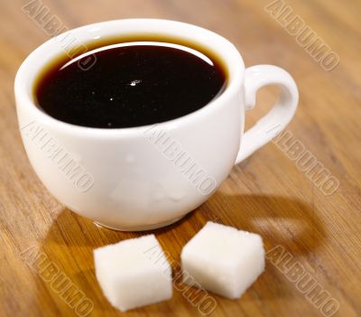 Espresso cup with pair of sugar on the wooden table