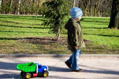 The little boy is playing with car.