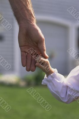 Father Daintily Holding Tiny Hand of Daughter