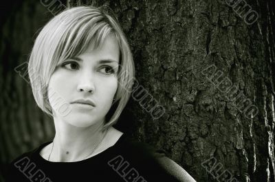 Sad young girl near the tree