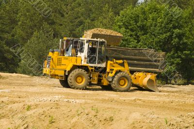 Heavy bulldozer loading ballast on the lorry