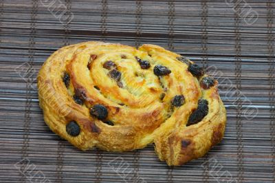 Freshly baked cinnamon roll on bakery paper