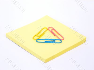 Colored and metal paper clips and sticky notes, isolated on white