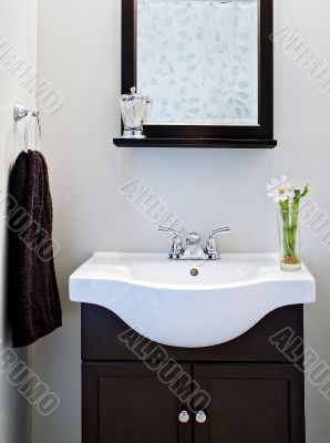 Black and white designer bathroom with mirror and flower