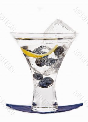 Blueberry cocktail in a glass with blueberries and ice cube on a