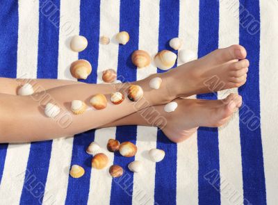 feet with shells on towel