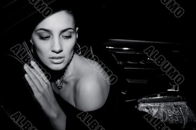 The glamour model poses in the black car