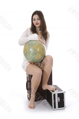 Young woman with  suitcase and globe