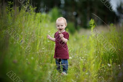 Smiling little baby in a meadow