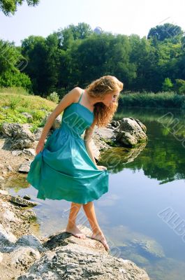 Sensual girl in dress near lake