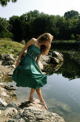 Sensual girl in dress near lake