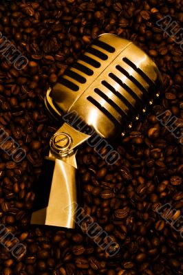 Retro-styled microphone laying on a coffee beans.