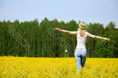 happy young woman is standing on a field
