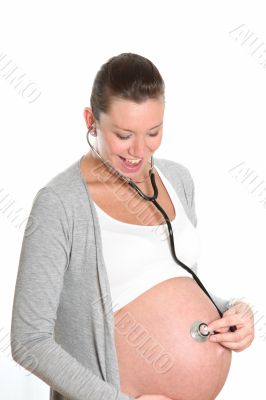 Happy, pregnant woman with stethoscope on belly