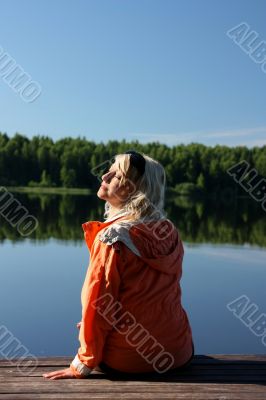 The girl meets morning on the shore of the river