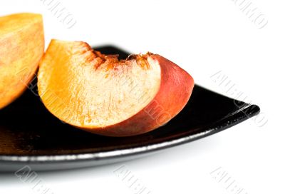 red peaches slices on black dish red peaches slices on black dish