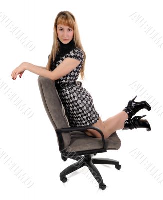 The girl kneeling in office armchair 