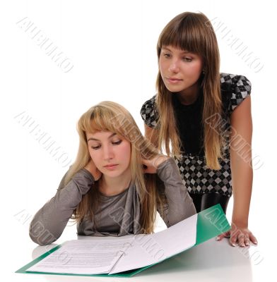 Two girls read documents.