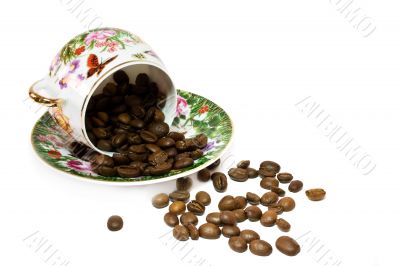 Coffee cup with scattering of coffee beans. Isolated on a white 