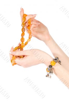 Hands holding amber necklace and bracelet