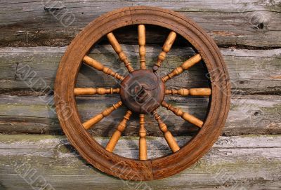 Spinning Wheel On The Log House Wall