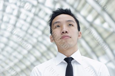 Asian male executive looking up