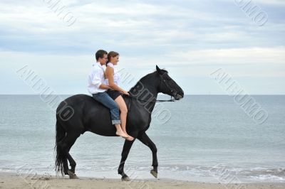couple and  horse on the beach
