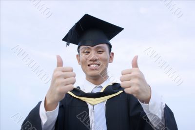 Happy asian graduate thumbs up