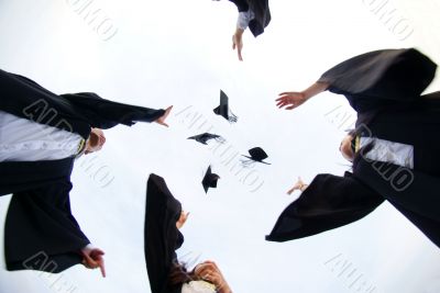 Happy graduates throw hats