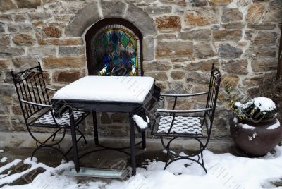 Table and Chairs Covered With Snow