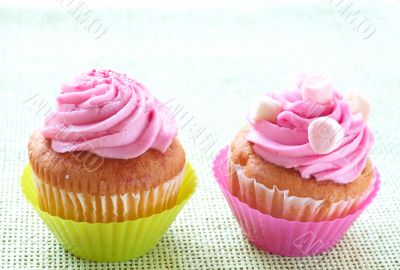 Small vanilla cupcakes with strawberry icing and marshmallows