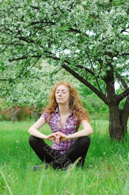 Woman meditating under blooming tree