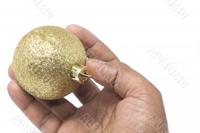 Hand holding a beautiful golden Christmas ball