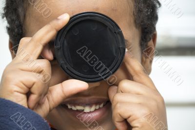 Young boy playing with a lens cover