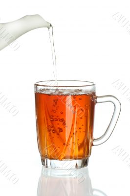 Pouring tea into transparent tea cup