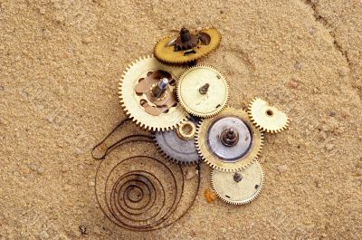 part of clockwork mechanism on the sand
