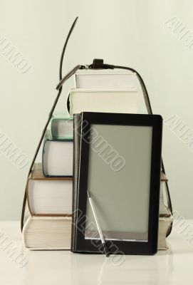 Stack of books and electronic book reader