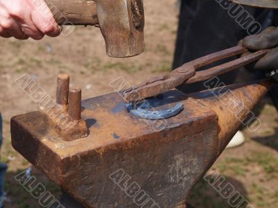 Making a horseshoe on an anvil in the forge