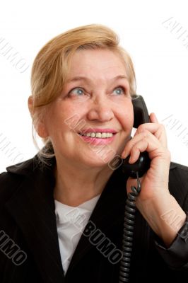 Senior Woman talking on the phone in black suite.