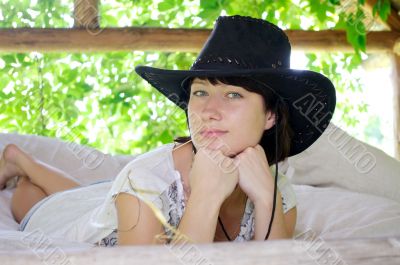 beautiful girl in the hat lying in the open air