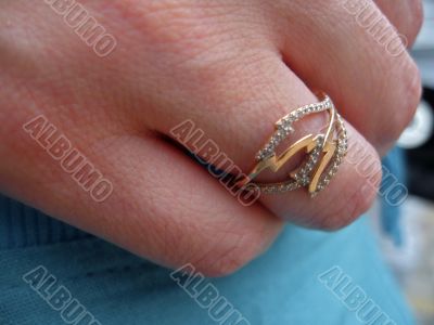 Golden ring with a stones on the finger of female