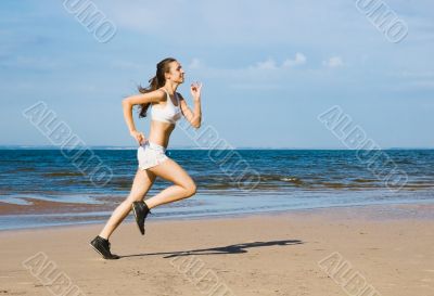 Young woman running alone on the beach