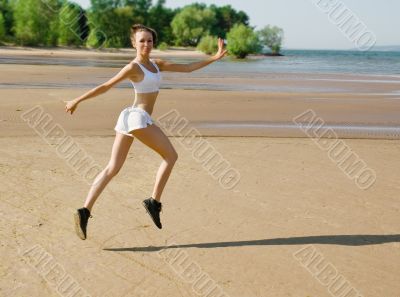 Young woman running alone on the beach