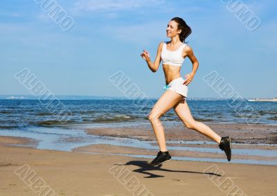 Young woman running alone on the beach