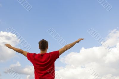 Young man staying with raised hands 