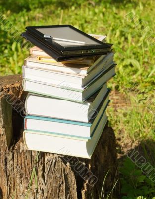 Stack of colorful books with e-book reader