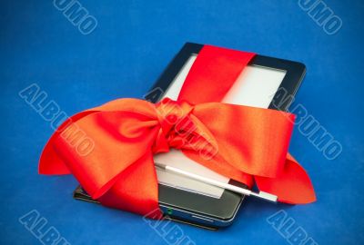 Electronic book reader tied up with red ribbon Electronic book reader tied up with red ribbon