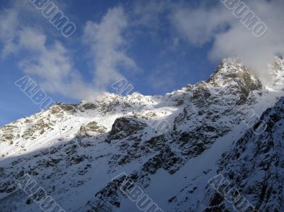 Mountain under the blue sky and the clouds